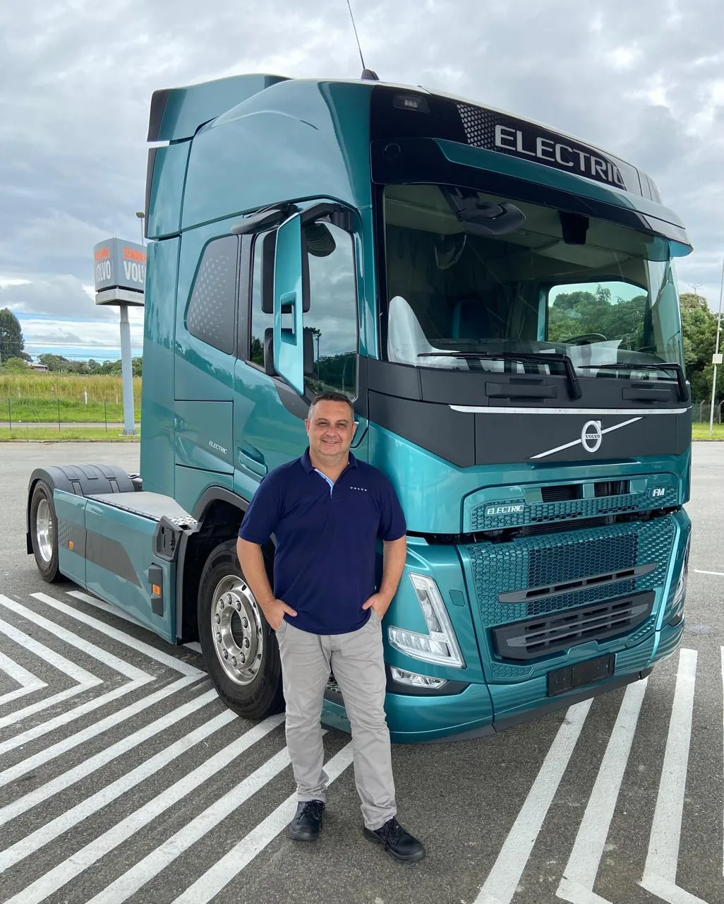 Fábio ao lado de um caminhão elétrico Volvo FM Electric